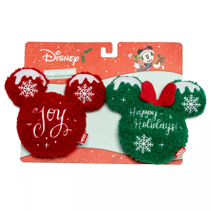 Disney holiday-themed dog toys featuring two plush Mickey Mouse head shapes with \“Joy\“ on a red toy and \“Happy Holidays\“ on a green toy, both with snowflake designs and squeakers.