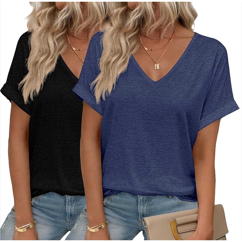 Two women wearing casual V-neck T-shirts, one in black and one in blue, paired with light blue jeans. They both have long blonde hair and are accessorized with gold necklaces and bracelets. One holds a beige clutch bag.