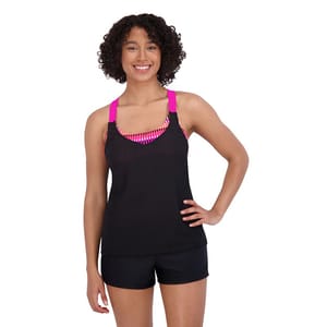 A woman models a black tankini top with a mesh design and bright pink straps, paired with matching black swim shorts.