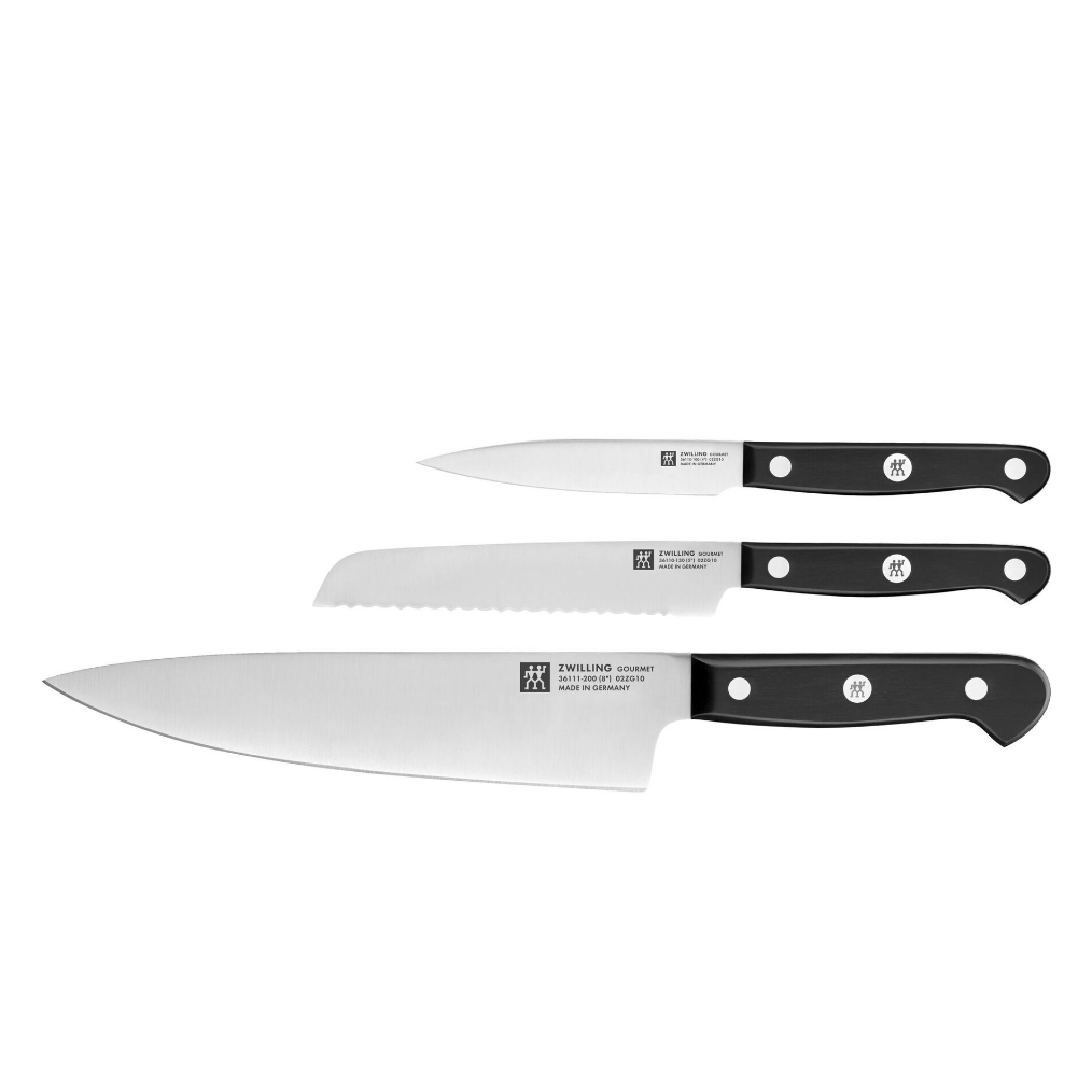 A set of three kitchen knives with black handles, including a chef's knife, a serrated bread knife, and a paring knife, all stamped with the Zwilling logo.