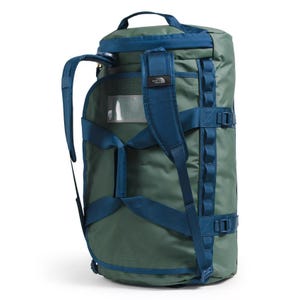 A green and blue duffel bag with a cylindrical shape, featuring adjustable shoulder straps, buckles, and a small transparent pocket on the side.