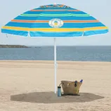 A colorful striped beach umbrella with the text \“Tommy Bahama, Live the Island Life\“ is set up on a sandy beach. Nearby is a woven straw bag containing a blue bottle and sunglasses, along with a tumbler on the sand.