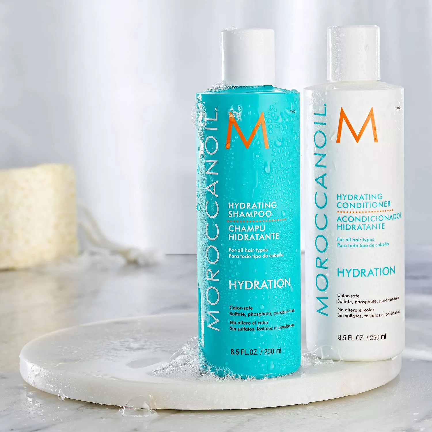 Two bottles of Moroccanoil Hydration: a turquoise Hydrating Shampoo and a white Hydrating Conditioner, each 8.5 fl oz/250 ml, suitable for all hair types and free from sulfates, phosphates, and parabens.