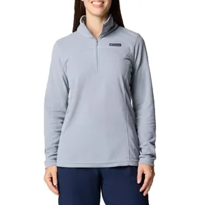 A woman is wearing a light blue Columbia half-zip fleece pullover and navy pants, standing against a white background.