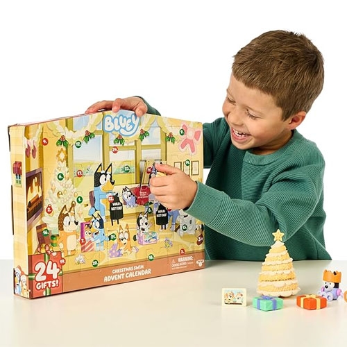 a child in a green sweater playing with a Bluey advent calendar toy