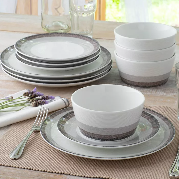 A set of ceramic dinnerware including plates, bowls, and cups in white and grey colors, with a textured design.