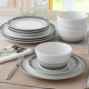 A set of ceramic dinnerware including plates, bowls, and cups in white and grey colors, with a textured design.