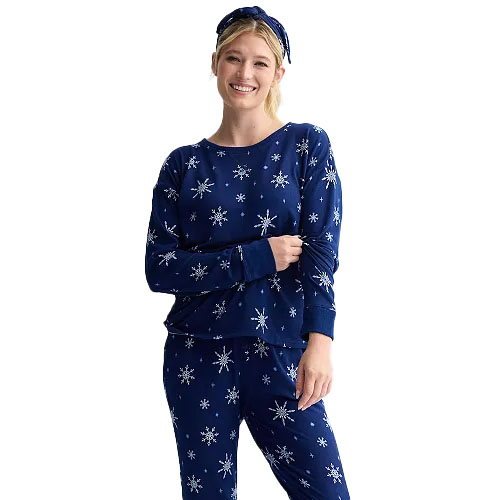 A woman wearing a matching dark blue pajama set with a snowflake pattern, complemented by a headband.