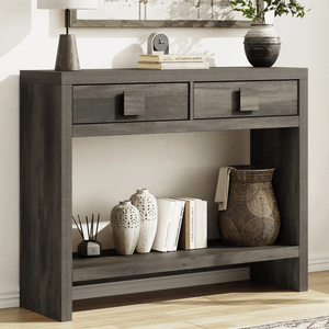 Dark wood console table with two drawers, displaying decorative vases, books, a wicker basket, and a small clock.