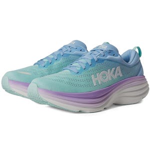 A pair of Hoka Bondi 8 running shoes in gradient shades of light blue to purple on the cushioned soles, with the brand name displayed on the side.