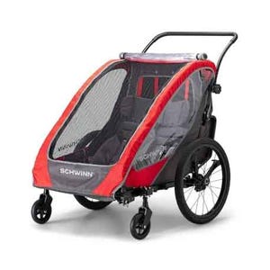 Schwinn Summit Double Bike Trailer is a child carrier with a red and gray design, featuring a protective mesh cover, two seats, and a handlebar for easy maneuvering. It has two large rear wheels and two smaller front wheels for stability.