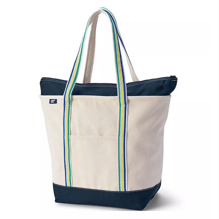 The Lands' End Large Canvas Tote is a sturdy bag with navy blue accents, featuring multicolored striped handles and an exterior pocket, ideal for carrying essentials.