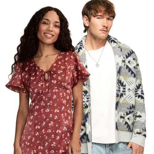 A woman in a red floral dress with short sleeves stands next to a man wearing a tribal-patterned cardigan over a white shirt and jeans.