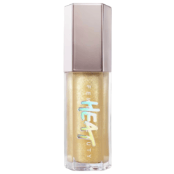 A Fenty Beauty gloss named \“Heat,\“ featuring a shimmering gold color in a transparent bottle with a metallic cap.