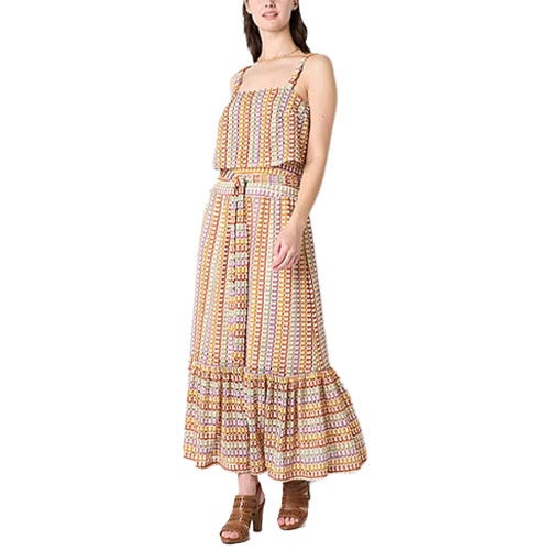 Sleeveless maxi dress with a geometric pattern, featuring a belted waist and ruffled hem. Worn with brown open-toed block-heel shoes.