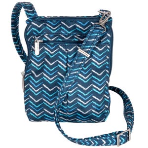 The Travelon Anti-Theft Slim Pouch features a blue chevron pattern with white and light blue accents, a zippered pocket, and an adjustable strap.