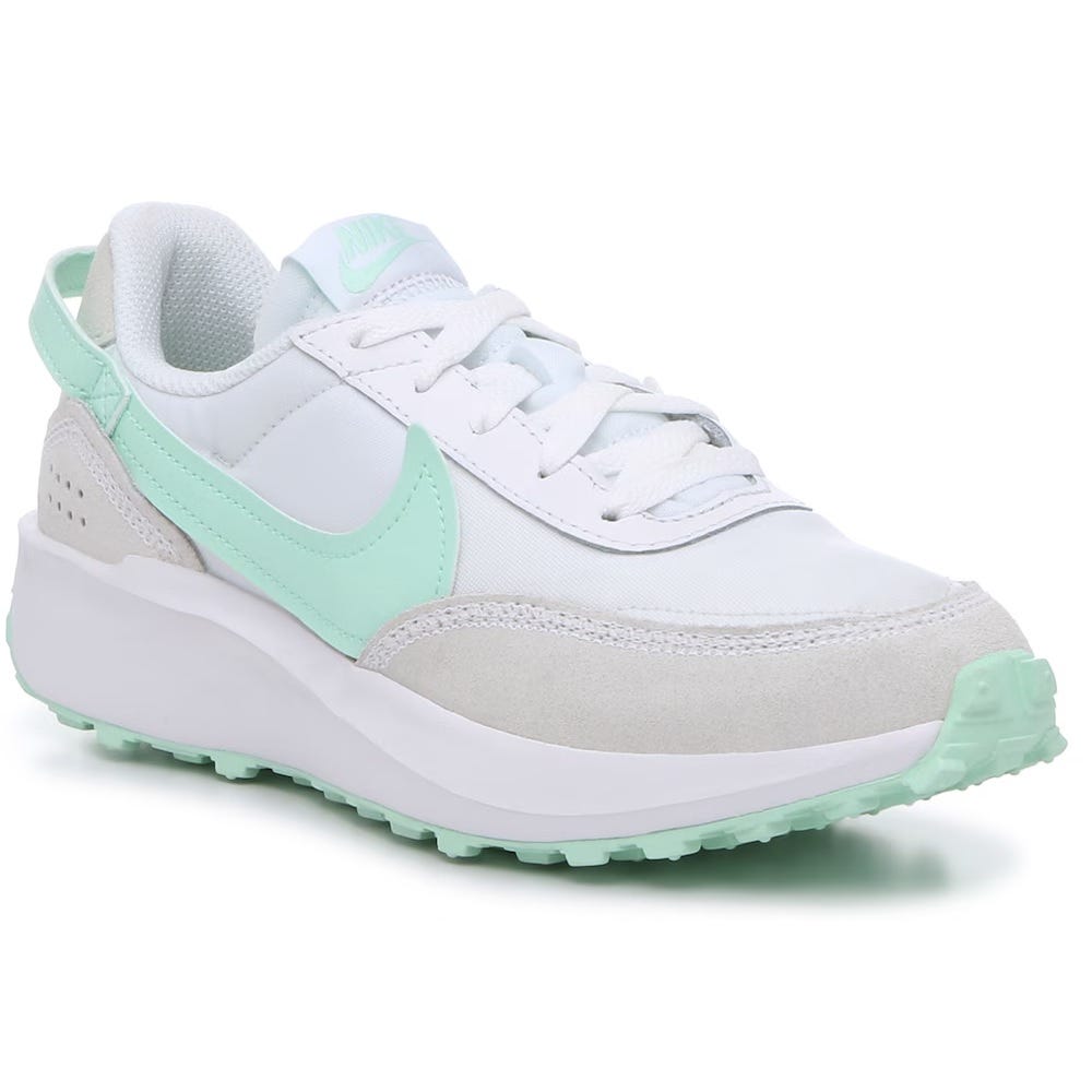 White and light green Nike Waffle Debut running shoes with a white upper, suede detail, and a waffle-patterned outsole.