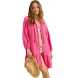 A woman wearing a pink cover-up dress over a floral print bikini holds a straw hat.