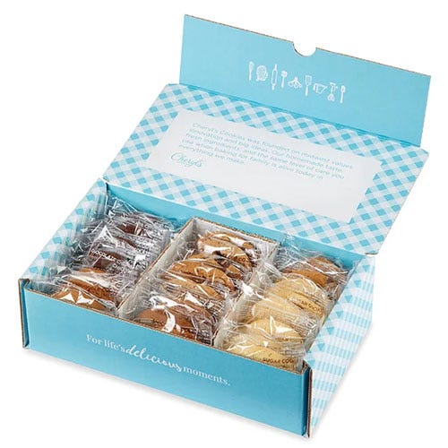 A neatly arranged gift box contains an assortment of individually wrapped cookies, housed in a blue and white checkered package with a festive design.