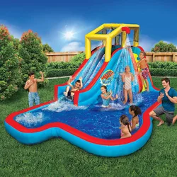 An inflatable water slide features multiple slides, a climbing wall, and a splash pool, with children and adults enjoying the setup in a backyard.