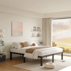 A minimalist bedroom setup features a metal bed frame with a white mattress, beige and brown bedding, and a side table. The room includes wall-mounted shelves with books, a soft rug, and a panoramic window with a sunset view.