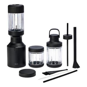 The Beast Mini Blender Bundle includes a sleek black blender base, two clear blending containers with black lids, a cleaning brush, a straw, and a tamper tool. The set is designed for compact and efficient blending, with a modern aesthetic.