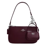 Burgundy Coach shoulder bag with silver hardware, featuring a detachable mini pouch attached by a silver clip.