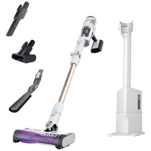 Cordless vacuum with a rose gold shaft, self-emptying base, and three attachments: a crevice tool, pet multi-tool, and flexible brush for versatile cleaning.