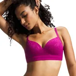 A woman poses wearing a vibrant pink, patterned bralette with adjustable straps, featuring a seamless design for comfort.