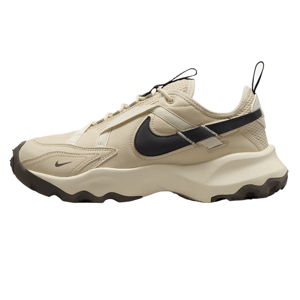 Nike Women's TC 7900 Shoes feature a beige upper with a black Swoosh, textured overlays, and a chunky, durable sole for a rugged, stylish look.