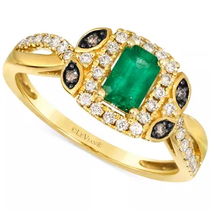 A gold ring featuring a rectangular emerald center stone, surrounded by white and dark diamonds, set in a decorative design.