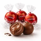 Lindt Lindor chocolate truffles in red packaging are shown, with one truffle cut open to reveal a creamy chocolate filling.