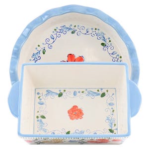 Two decorative ceramic baking dishes are shown, one rectangular and the other round, both with floral patterns and blue trim.