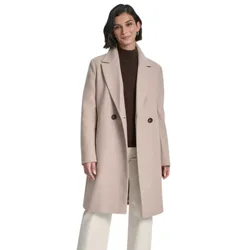 A woman is wearing a long beige coat with two buttons over a brown turtleneck sweater, paired with cream-colored wide-leg pants and dark ankle boots.