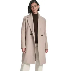 A woman is wearing a long beige coat with two buttons over a brown turtleneck sweater, paired with cream-colored wide-leg pants and dark ankle boots.