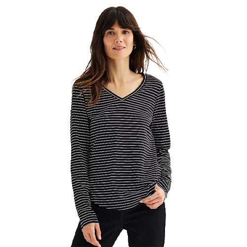 A woman wearing a black and white striped long-sleeve V-neck shirt paired with black pants.