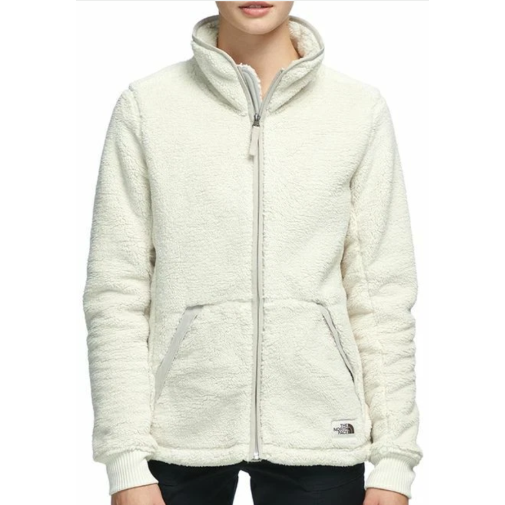 A cream-colored fleece jacket with a full front zipper and two pockets, featuring The North Face logo near the hem.