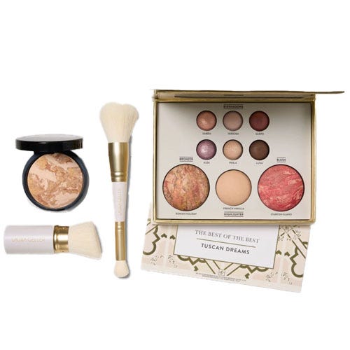 A makeup collection including a palette with various baked eyeshadows and blushes, a powder compact, and two fluffy makeup brushes, all themed \“Tuscan Dreams.\“