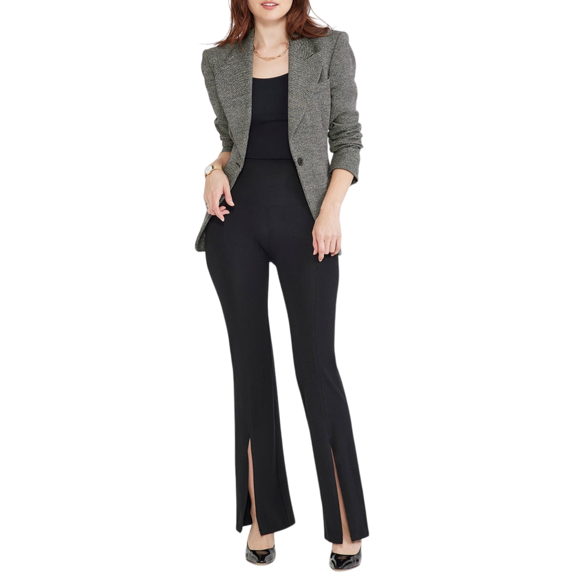 Woman wearing a gray blazer with a black top and black flared pants featuring front slits, paired with black heels.