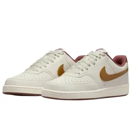 A pair of low-top white sneakers with a brown swoosh and maroon lining, featuring perforated toe caps and white laces.