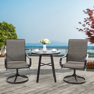 A 3-piece patio bistro set featuring a round table with a slatted top and a vase of flowers, accompanied by two swivel chairs with gray textilene mesh seats and black metal frames, set on a paved outdoor area with a scenic view.