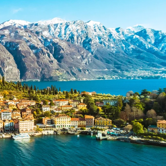 A picturesque lakeside town with colorful buildings, nestled at the foot of snow-capped mountains.