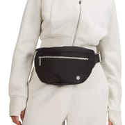 A black lululemon Large Belt Bag worn around the waist, featuring a front zipper pocket and adjustable strap, designed for hands-free convenience and secure storage.