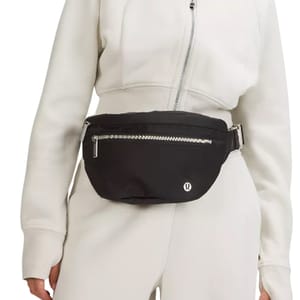 A black lululemon Large Belt Bag worn around the waist, featuring a front zipper pocket and adjustable strap, designed for hands-free convenience and secure storage.