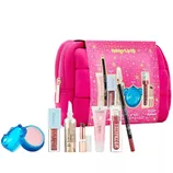 Sephora Favorites Holiday Lip Kit includes a variety of lip products and a bright pink bag. The kit features lip gloss, lip balm, lipstick, and a lip pencil, showcasing brands like Pat McGrath Labs, NARS, and KOSAS.
