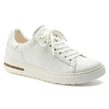 White leather sneaker with lace-up design and a gold accent on the heel.