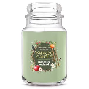 Yankee Candle from the Fantastical Fall Collection, scent \“Enchanted Orchard,\“ in a large glass jar with a green hue and botanical-themed label.