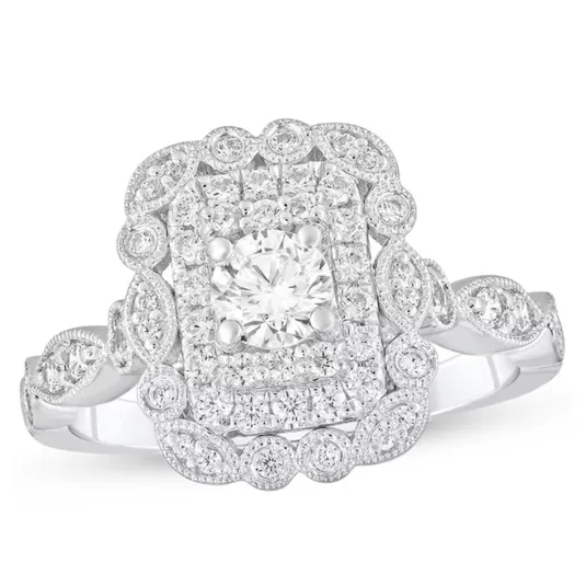 Ornate white gold ring with a central round diamond surrounded by a rectangular cluster of smaller diamonds and intricate milgrain detailing.