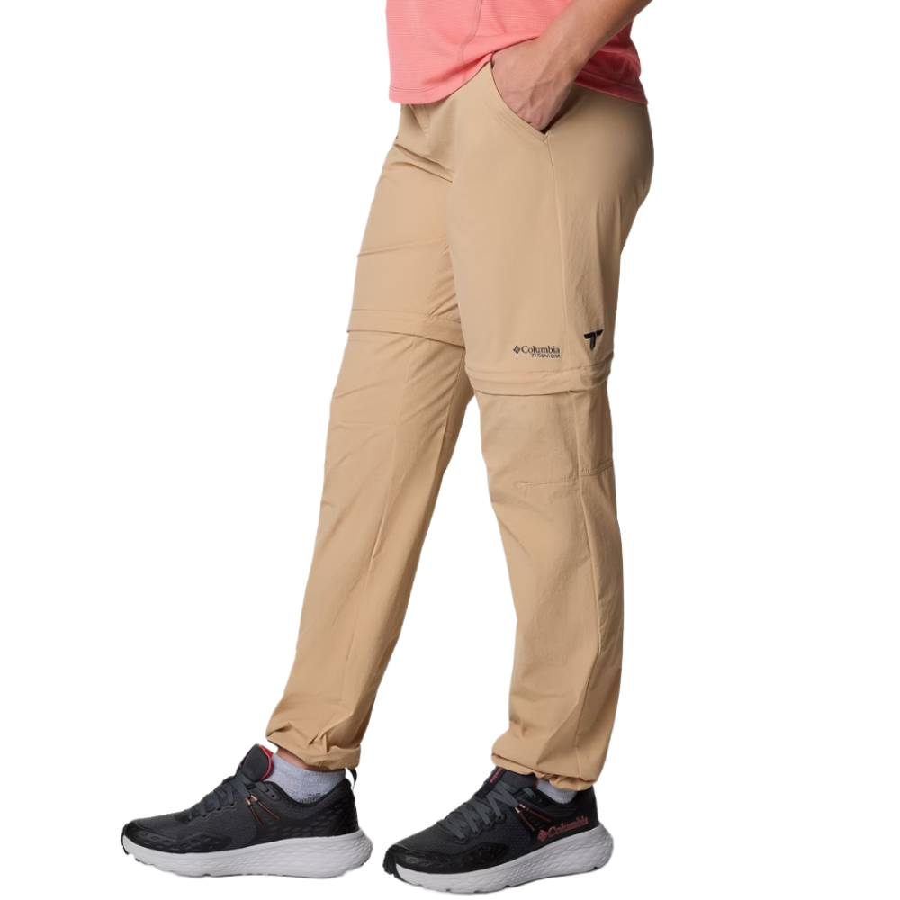 Beige Columbia convertible hiking pants with zip-off legs, paired with black and gray athletic shoes.