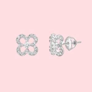 Pair of silver stud earrings with a floral design adorned with small diamonds, set against a pink background.